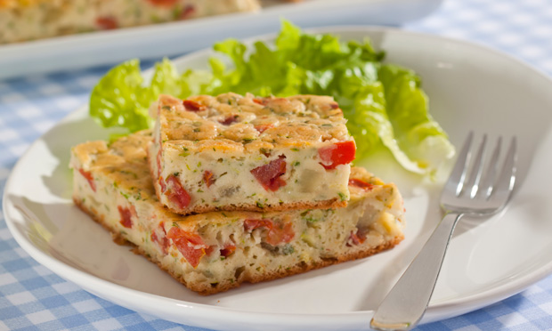 Pedaço de torta de abobrinha com tomate.