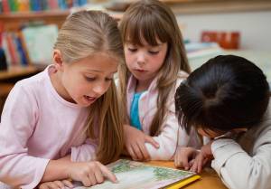 crianças lendo livro na escola