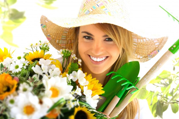 mulher-feliz-com-flores-e-ferramentas-de-jardinagem_1320-578