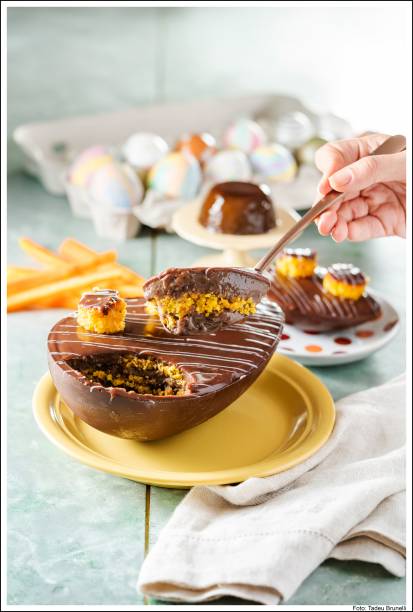 Dona Deôla - Ovo Bolo de Cenoura com Pudim de Chocolate. Casca de chocolate recheada de bolo de cenoura e pudim de chocolate cremoso, coberto com ganache de chocolate e mini bolos de cenouras. Preço: R$ 69,90.