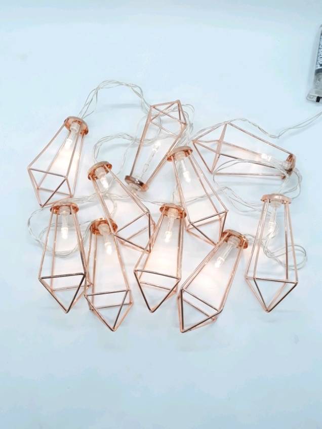 <span>Cordão com 180 cm de comprimento e </span>10 mini luminárias de LED. <a href="https://www.madeiramadeira.com.br/luminaria-cordao-de-luz-rose-gold-cobre-geometrico-1760419.html" target="_blank" rel="noopener">MadeiraMadeira</a>, R$ 49,90 <span>Cordão com 180 cm de comprimento e </span>10 mini luminárias de LED. <a href="https://www.madeiramadeira.com.br/luminaria-cordao-de-luz-rose-gold-cobre-geometrico-1760419.html" target="_blank" rel="noopener">MadeiraMadeira</a>, R$ 49,90