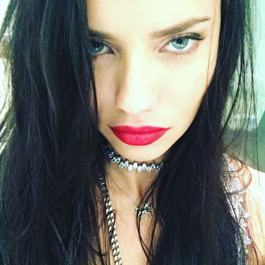 Adriana Lima apostou no look fatal, com cabelos lisos e soltos, cílios alongados e batom vermelho.