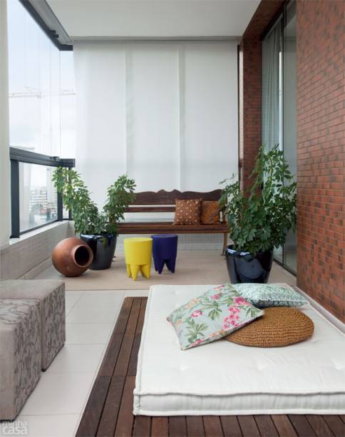 Relaxar e bater papo. Eis o que a moradora faz na porção da varanda reservada a um tablado de madeira com futon. Vasos esmaltados e banquinhos de polipropileno colorido atenuam a rusticidade. Projeto de Marcia Meccia. Relaxar e bater papo. Eis o que a moradora faz na porção da varanda reservada a um tablado de madeira com futon. Vasos esmaltados e banquinhos de polipropileno colorido atenuam a rusticidade. Projeto de Marcia Meccia.