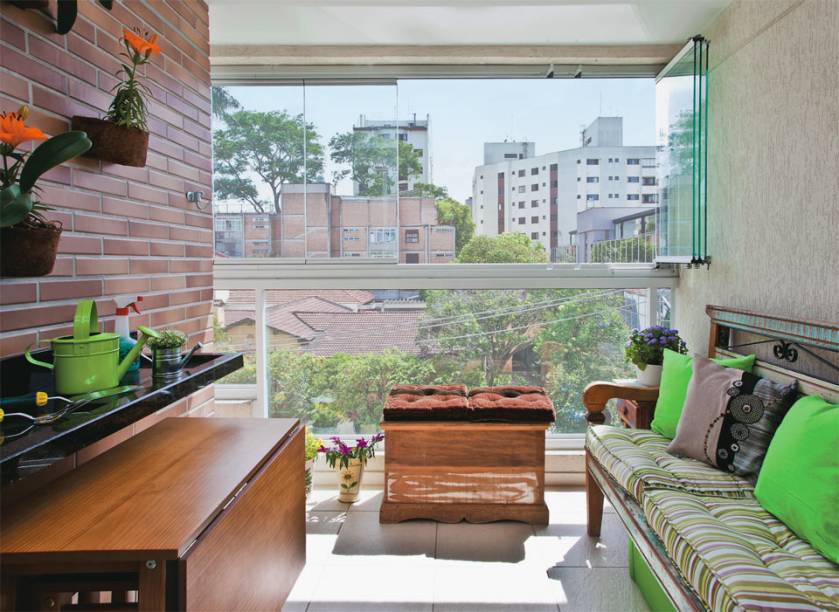 Extensão da sala, a área foi fechada com folhas de vidro móveis. O visual rústico inspirou a escolha do mobiliário. O terraço contempla rede, churrasqueira e mesa de refeições. Toda essa estrutura, no entanto, só aparece na hora certa: rede e churrasqueira portátil ficam dentro do baú. Quando fechada, a peça recebe futons e vira opção de assento. Alojada sob a bancada de granito, a mesa dobrável é para dois, porém duplica quando aberta, acomodando quatro pessoas. Extensão da sala, a área foi fechada com folhas de vidro móveis. O visual rústico inspirou a escolha do mobiliário. O terraço contempla rede, churrasqueira e mesa de refeições. Toda essa estrutura, no entanto, só aparece na hora certa: rede e churrasqueira portátil ficam dentro do baú. Quando fechada, a peça recebe futons e vira opção de assento. Alojada sob a bancada de granito, a mesa dobrável é para dois, porém duplica quando aberta, acomodando quatro pessoas.