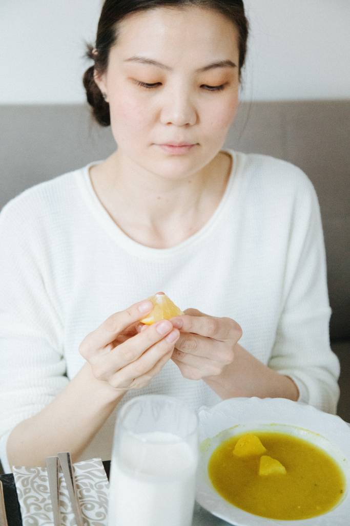 Mulher tomando uma sopa