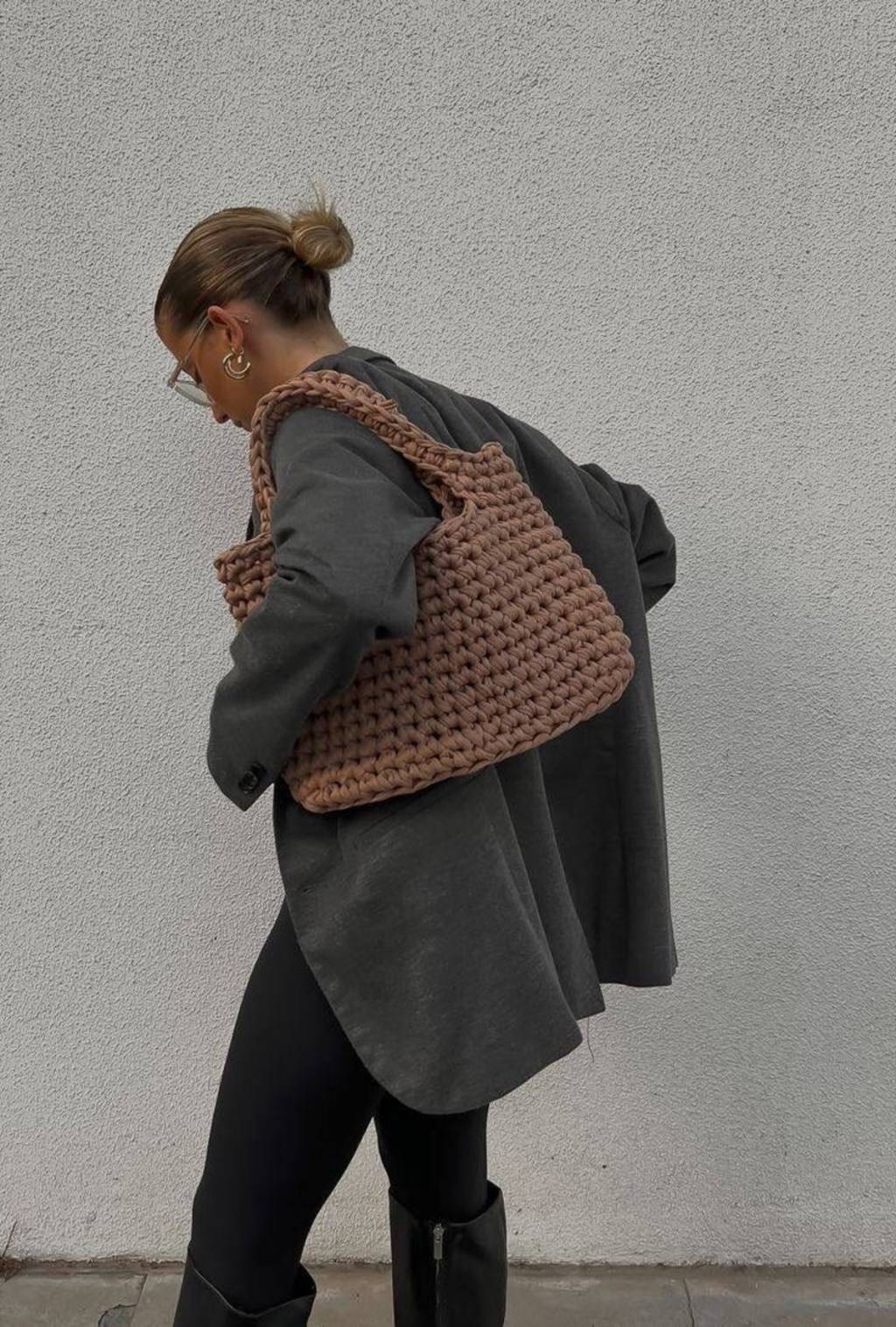 Bolsa Artesanal Mulher usando bolsa de ombro em material artesanal, na cor marrom claro.