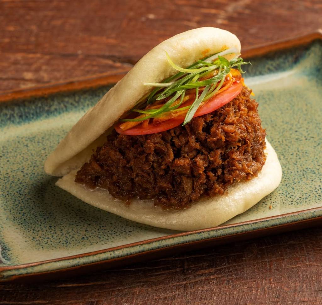 lollapalooza-2025-jojo-ramen-bao (1) Pork Bun, do Jojo Ramen, é um pão cozido em vapor com recheio de porco picado adocicado, maionese de karashi (mostarda japonesa), picles de rabanete, alho poró apimentado (kara negui) e cebolinha, que estará à venda por R$ 36 no Chef's Stage do Lollapalooza 2025
