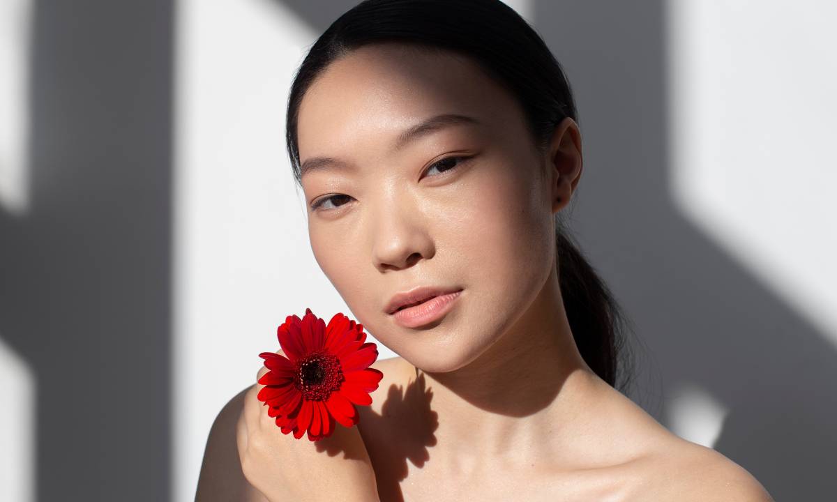 Mulher coreana segurando uma rosa vermelha
