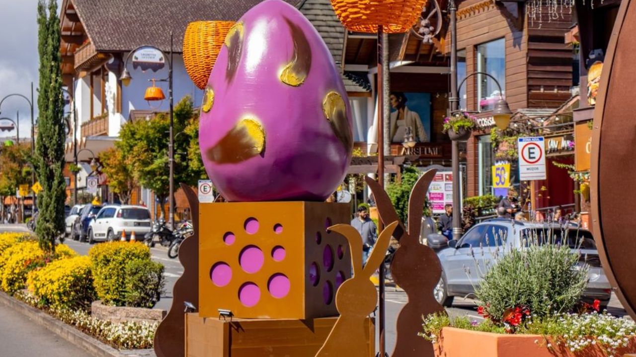 Cidade enfeitada com ovos de páscoa gigantes e coelhinhos de enfeite.