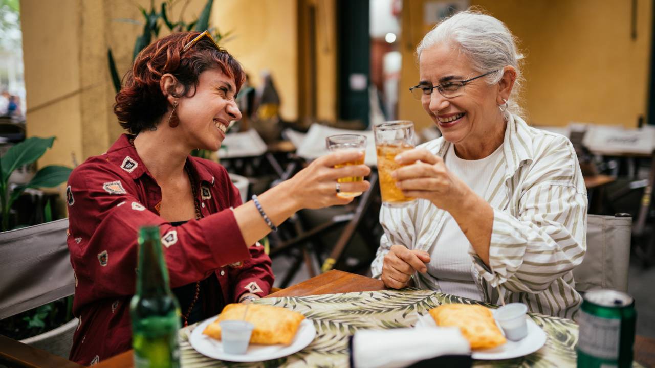 Mãe brindando com a sua filha em um restaurante no Dia das Mães.