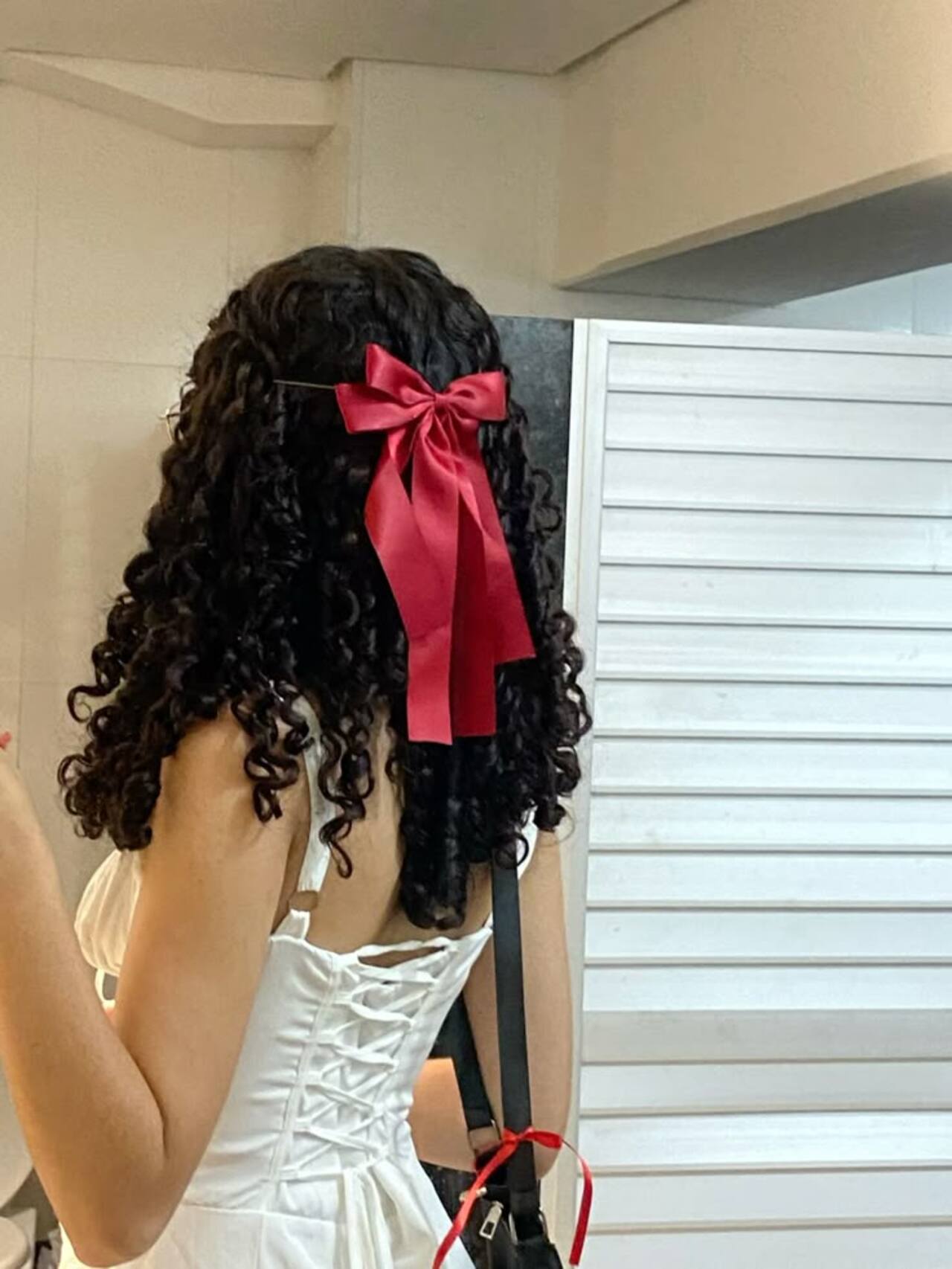 Imagem de cabelos cacheados pretos com la&ccedil;o rosa.