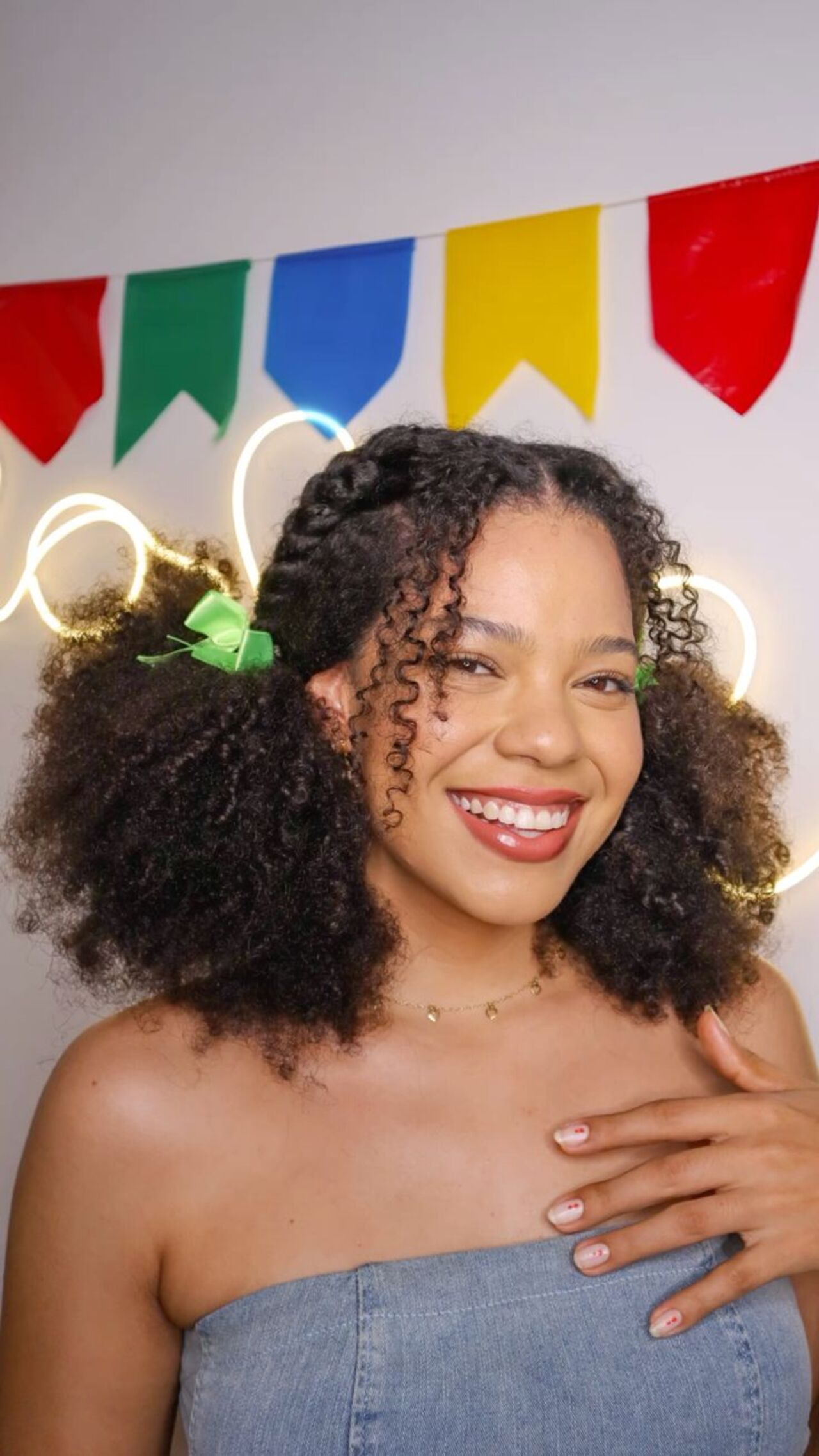 Imagem de mulher negra com penteado de dois coques e tran&ccedil;as.