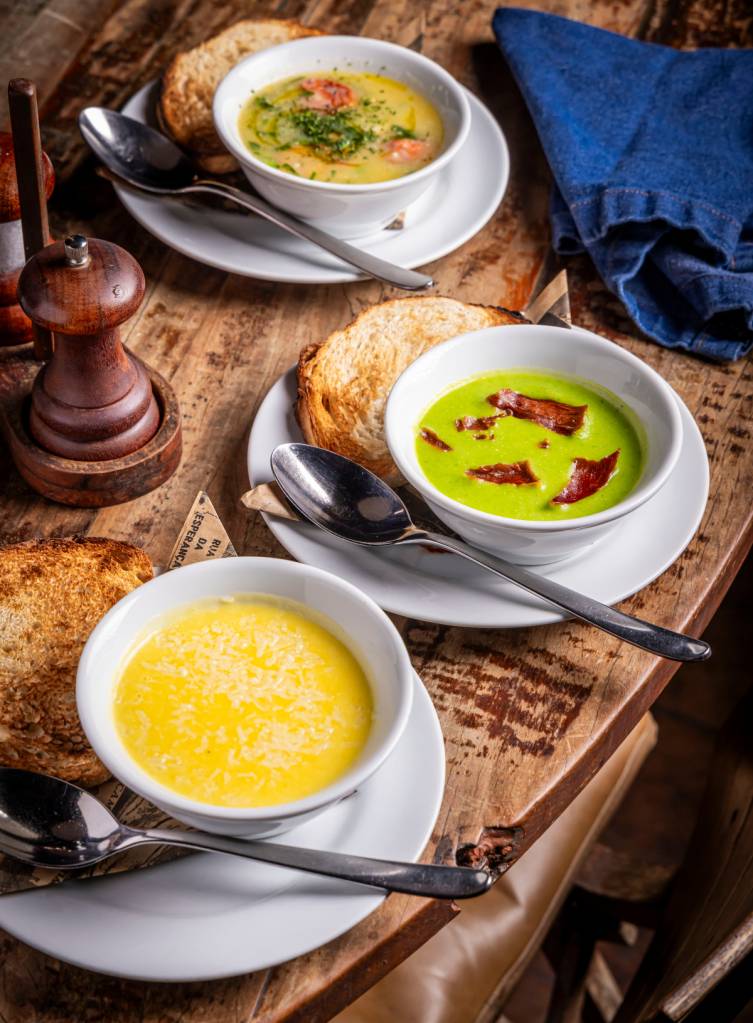 Creme de mandioquinha, creme de ervilha com jamón e caldo verde, servidas no Adega Santiago e Adega Santiago Asador