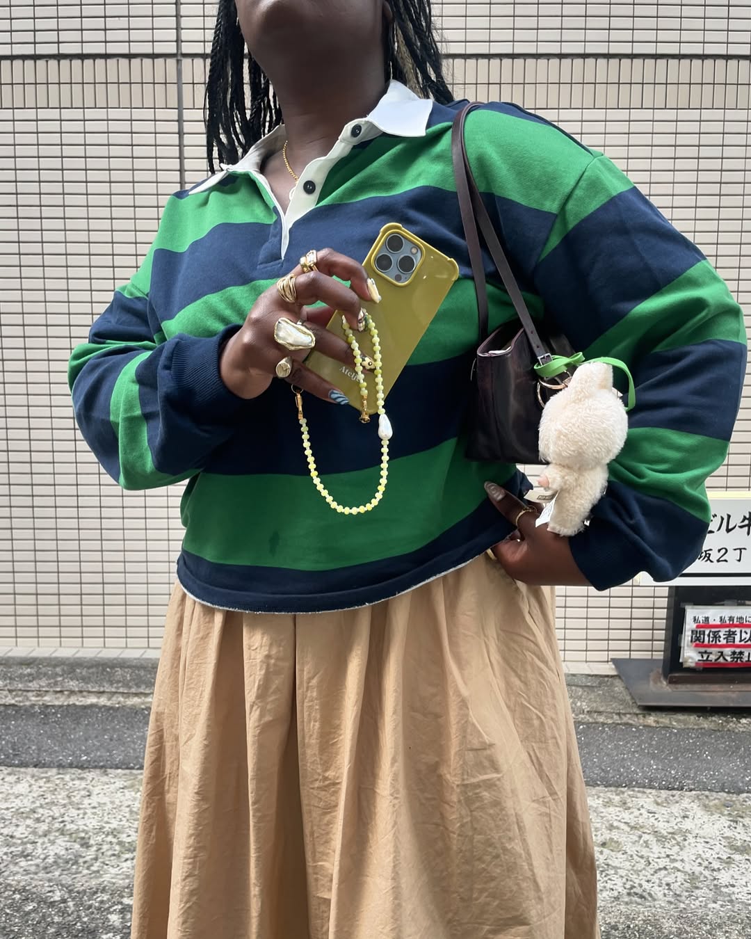 Look com polo listrada e saia midi bege