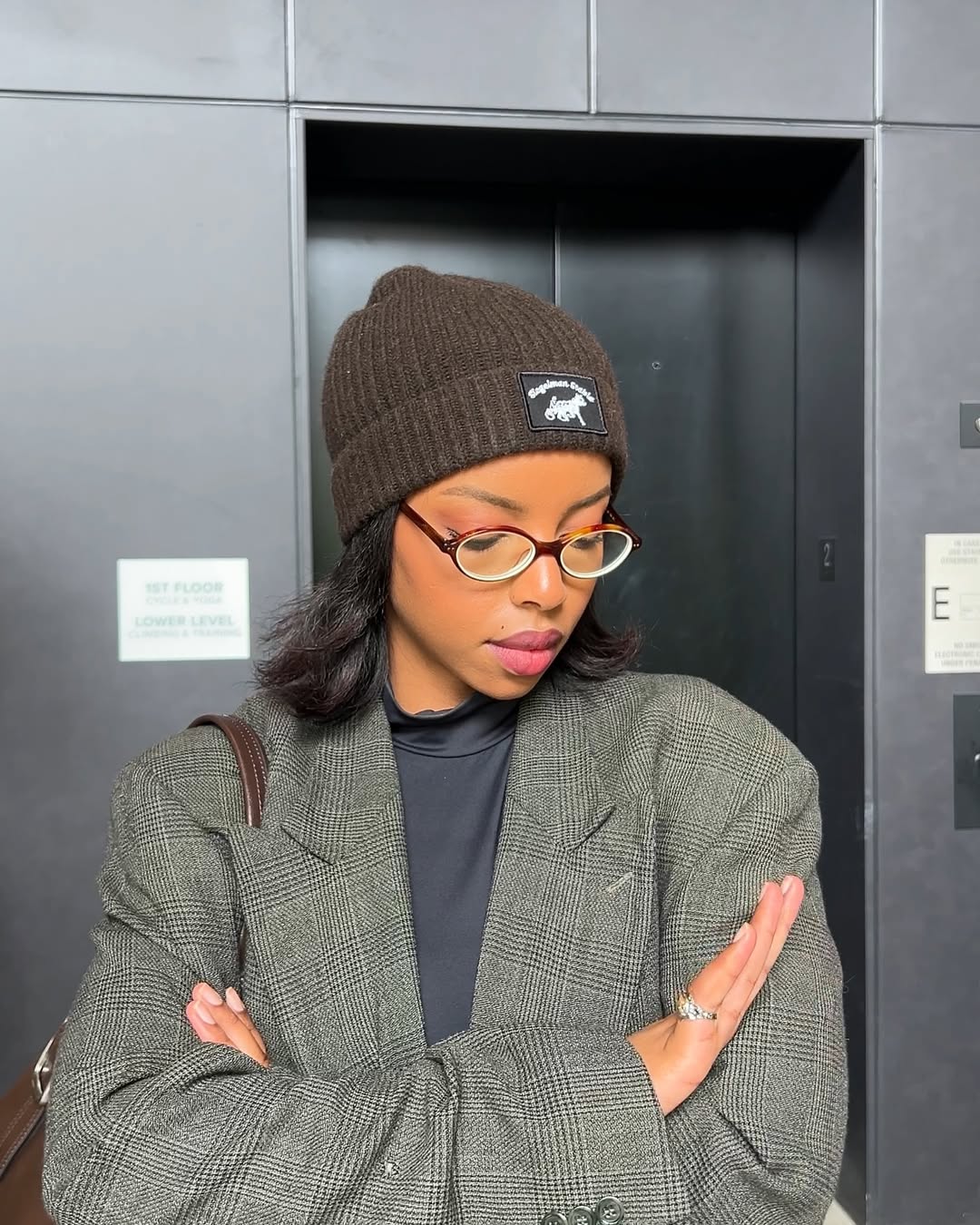 Look de inverno com touca preta de l&atilde; e blazer xadrez