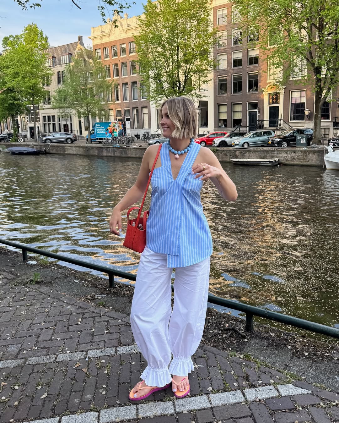 Blusa azul listrada com cal&ccedil;a branca ampla em look leve e colorido