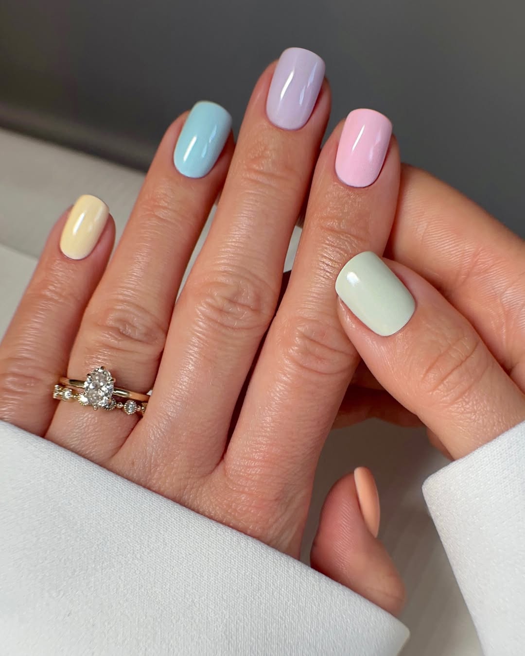 Unhas esmaltadas em mix de cores past&eacute;is suaves