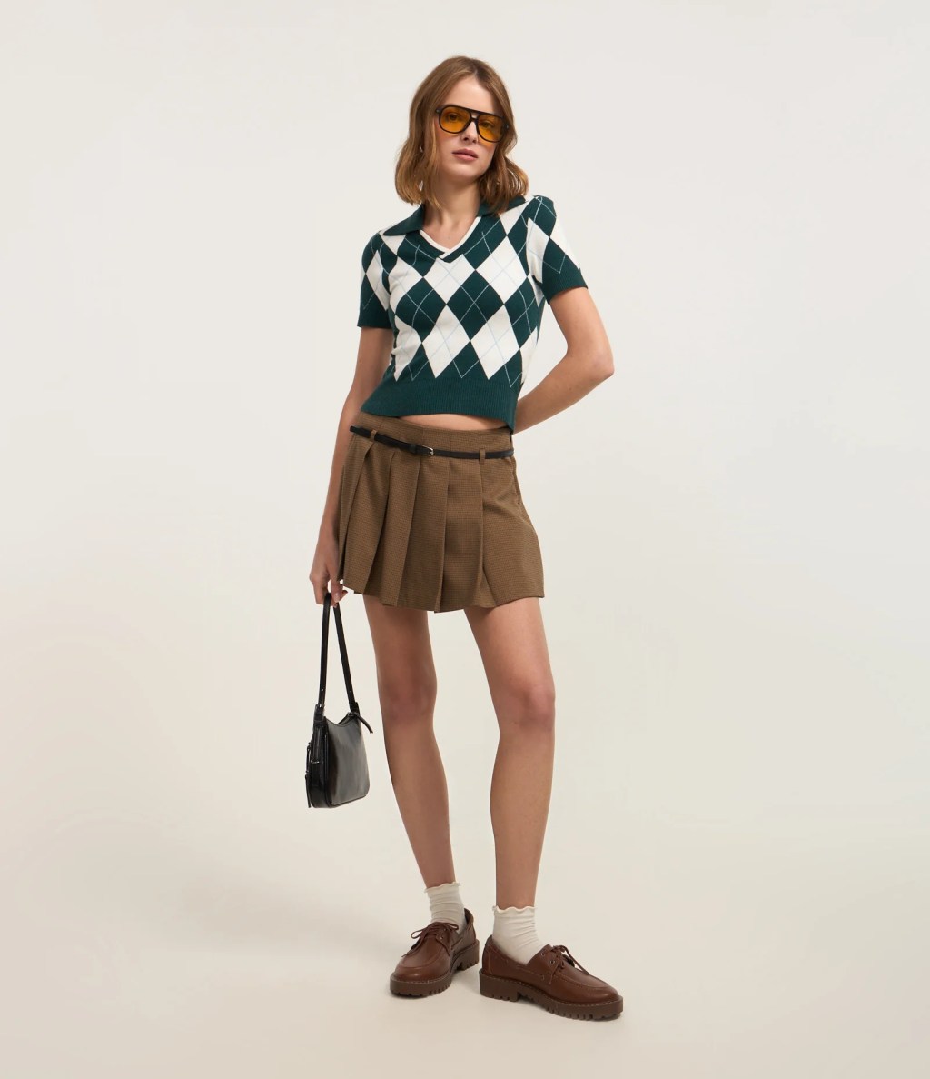 Foto de uma mulher usando uma saia plissada marrom