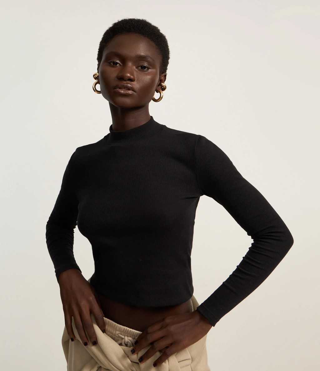 Foto de uma mulher negra usando uma blusa de frio preta