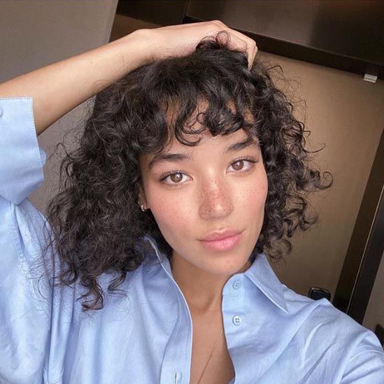 Franja cacheada: corte leve que valoriza a textura natural e os cachos definidos