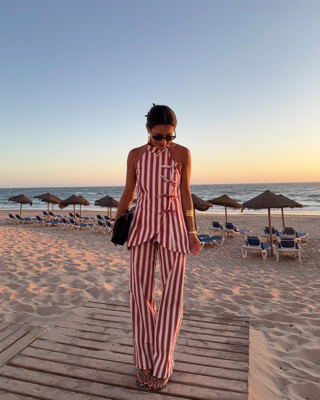 Foto de uma mulher usando um look composto por conjunto de regata e cal&ccedil;a listradas vermelha