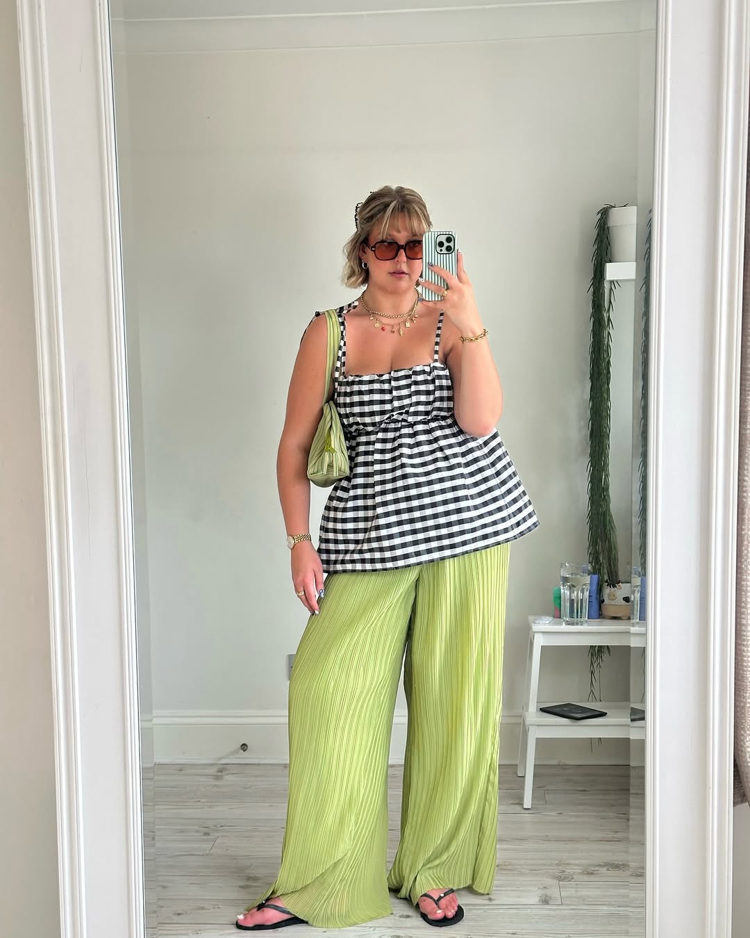 Cal&ccedil;a plissada verde pastel com blusa xadrez em look moderno para primavera