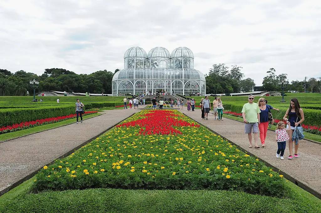 Imagem de jardim com flores e prédio de vidro no Jardim Botânico de Curitiba