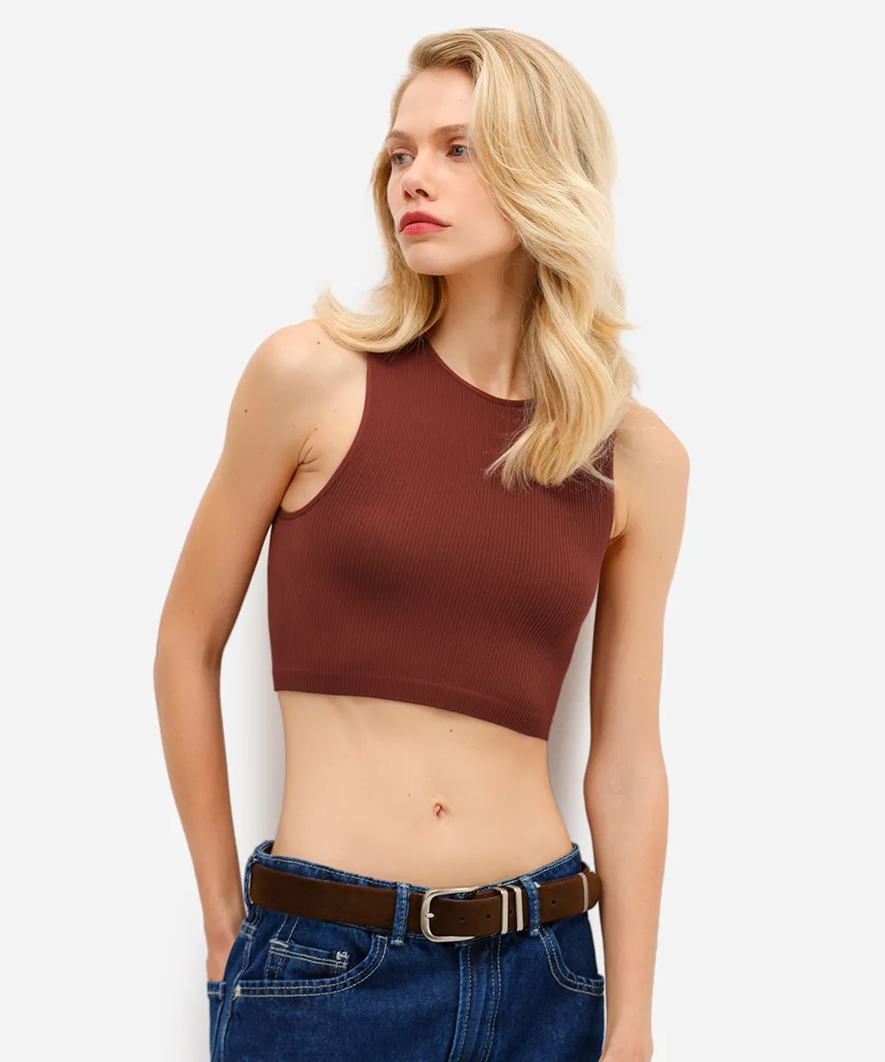 Foto de uma mulher loira usando uma regata marrom