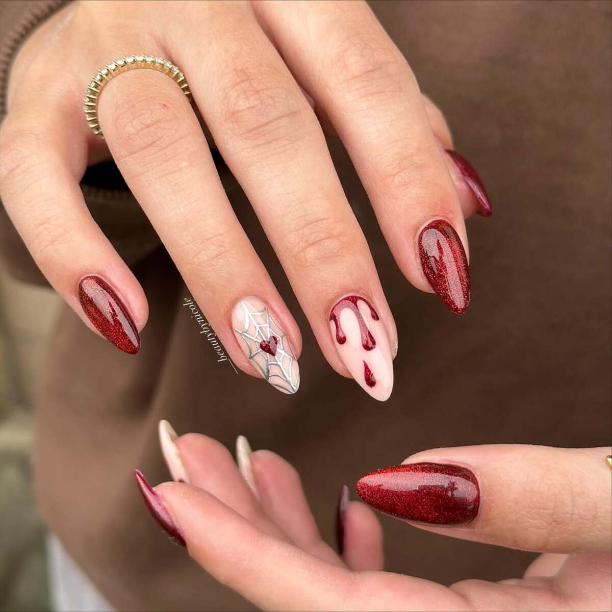 Imagem mostra unhas amendoadas vermelhas com decora&ccedil;&atilde;o de cora&ccedil;&atilde;o e sangue derramando.