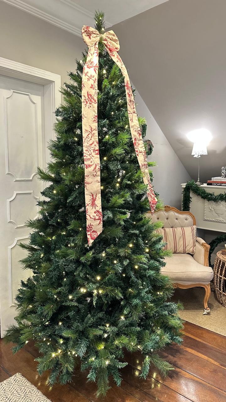 &Aacute;rvore de Natal grande com luzes pisca pisca e la&ccedil;o no topo