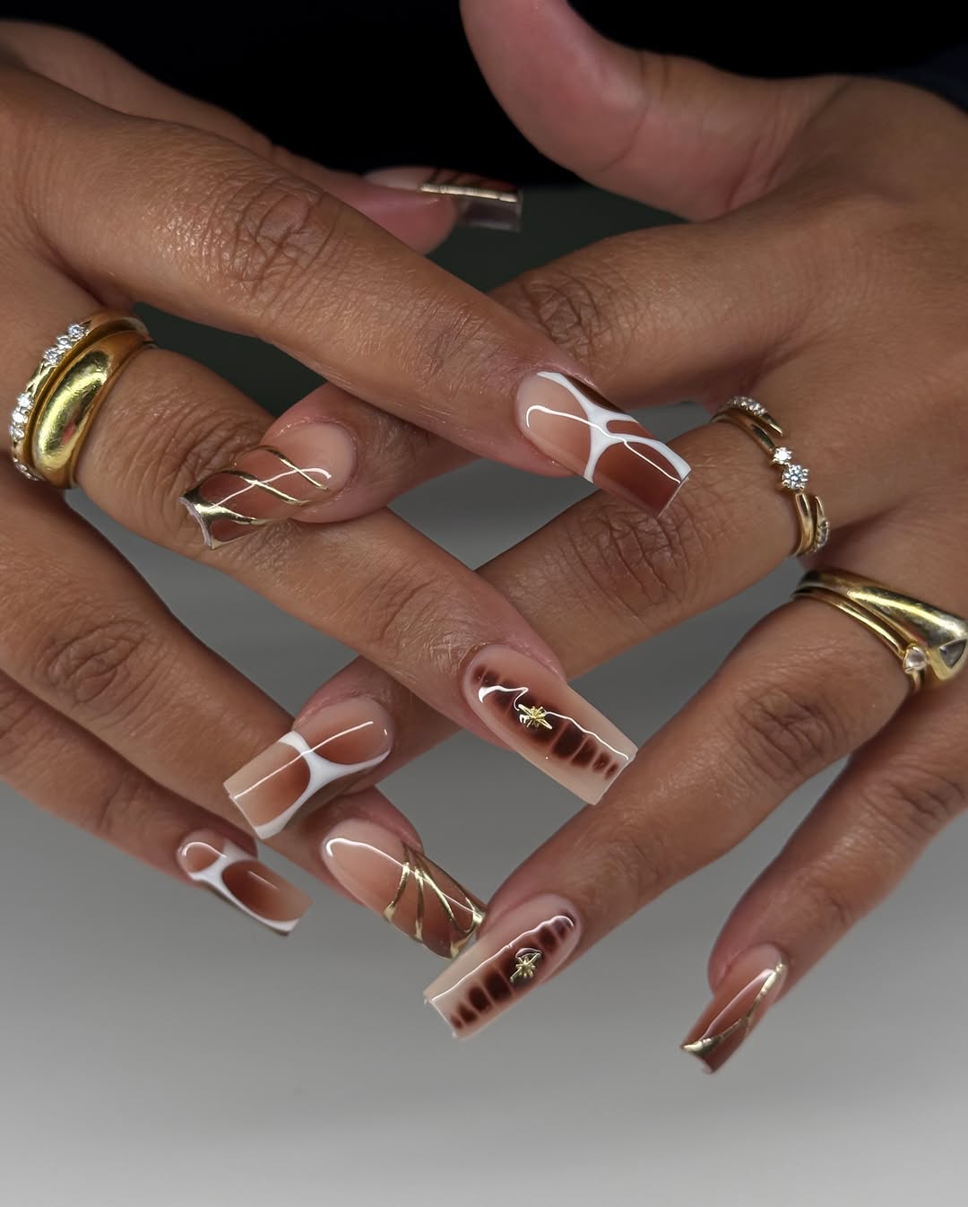 Unhas acrigel decoradas em tons neutros e detalhes dourados