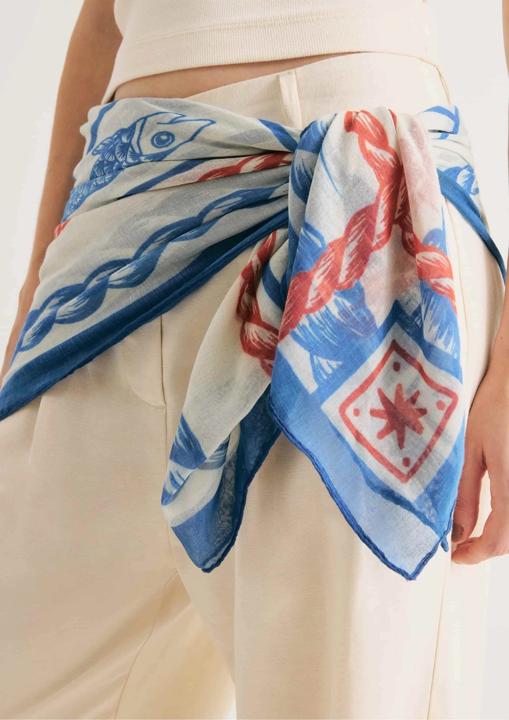 Foto de um len&ccedil;o com detalhes brancos, azuis e vermelhos. Ele est&aacute; amarrado na cintura de uma mulher