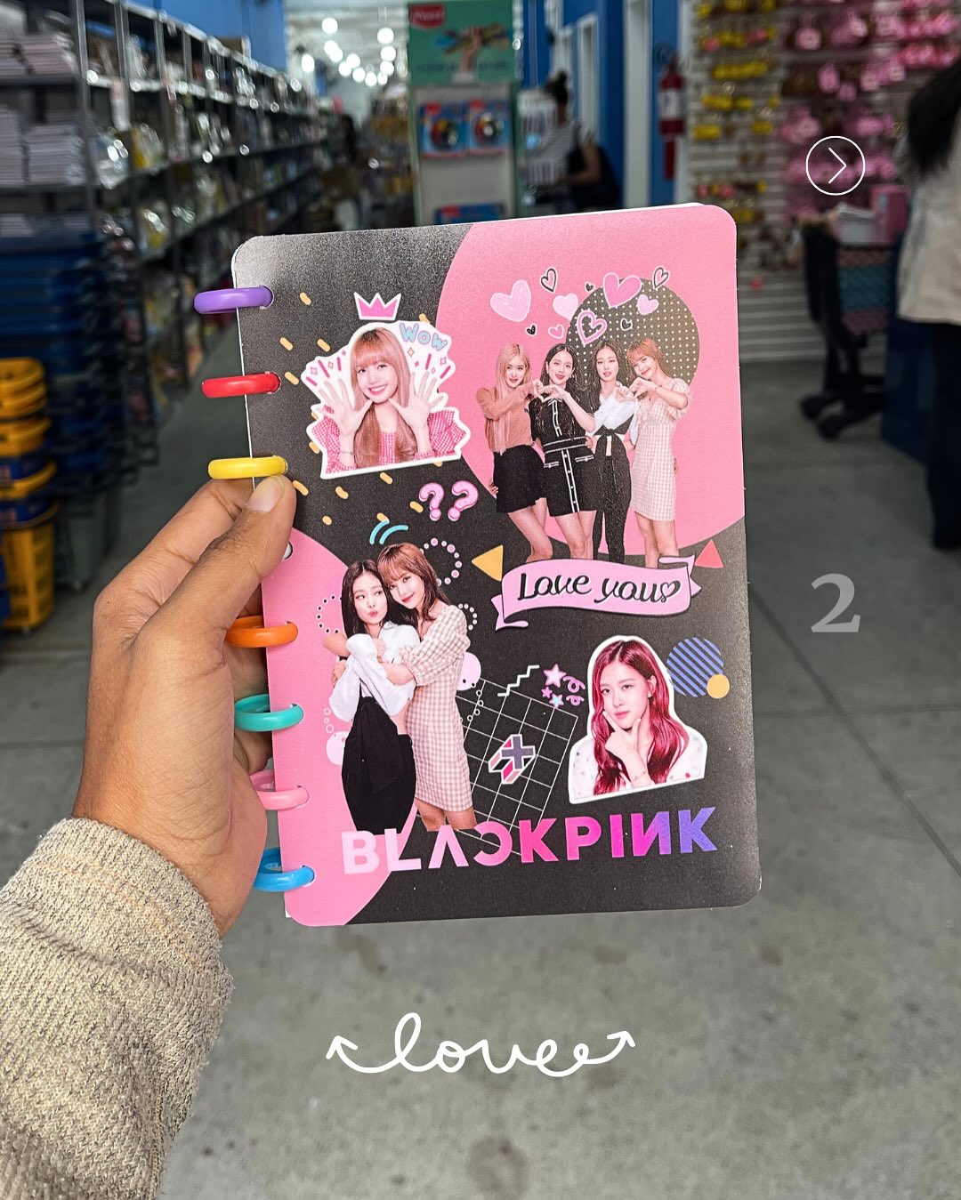 Foto de um caderno da banda Black Pink. As mulheres da banda est&atilde;o presentes na imagem, al&eacute;m de elementos na cor rosa, preto e roxo
