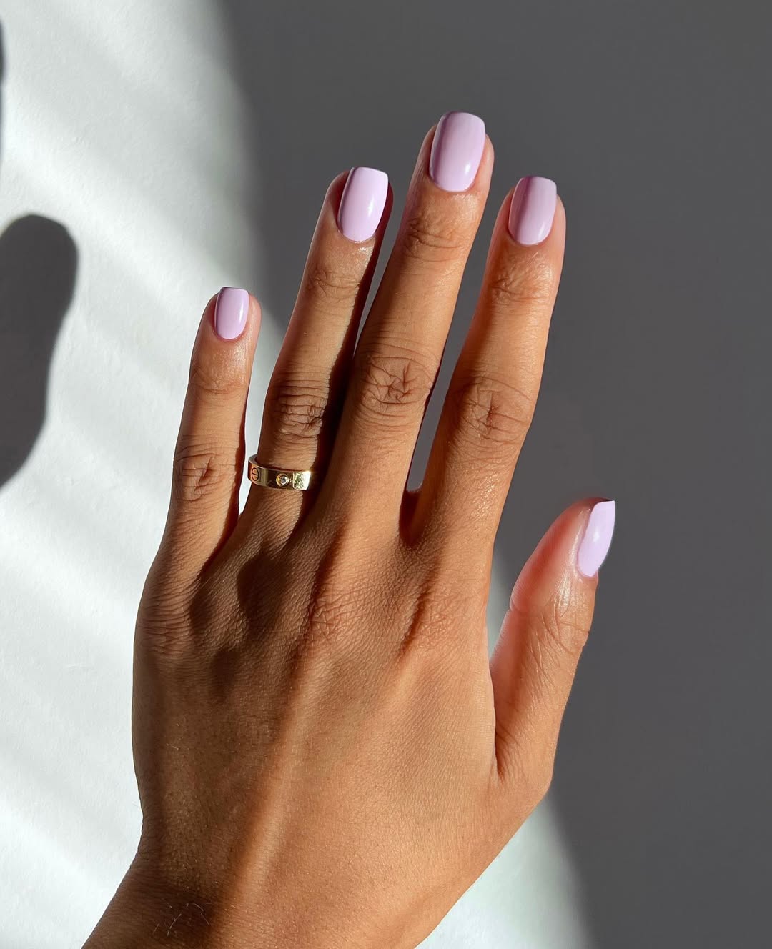 Foto de uma m&atilde;o com as unhas coloridas de rosa