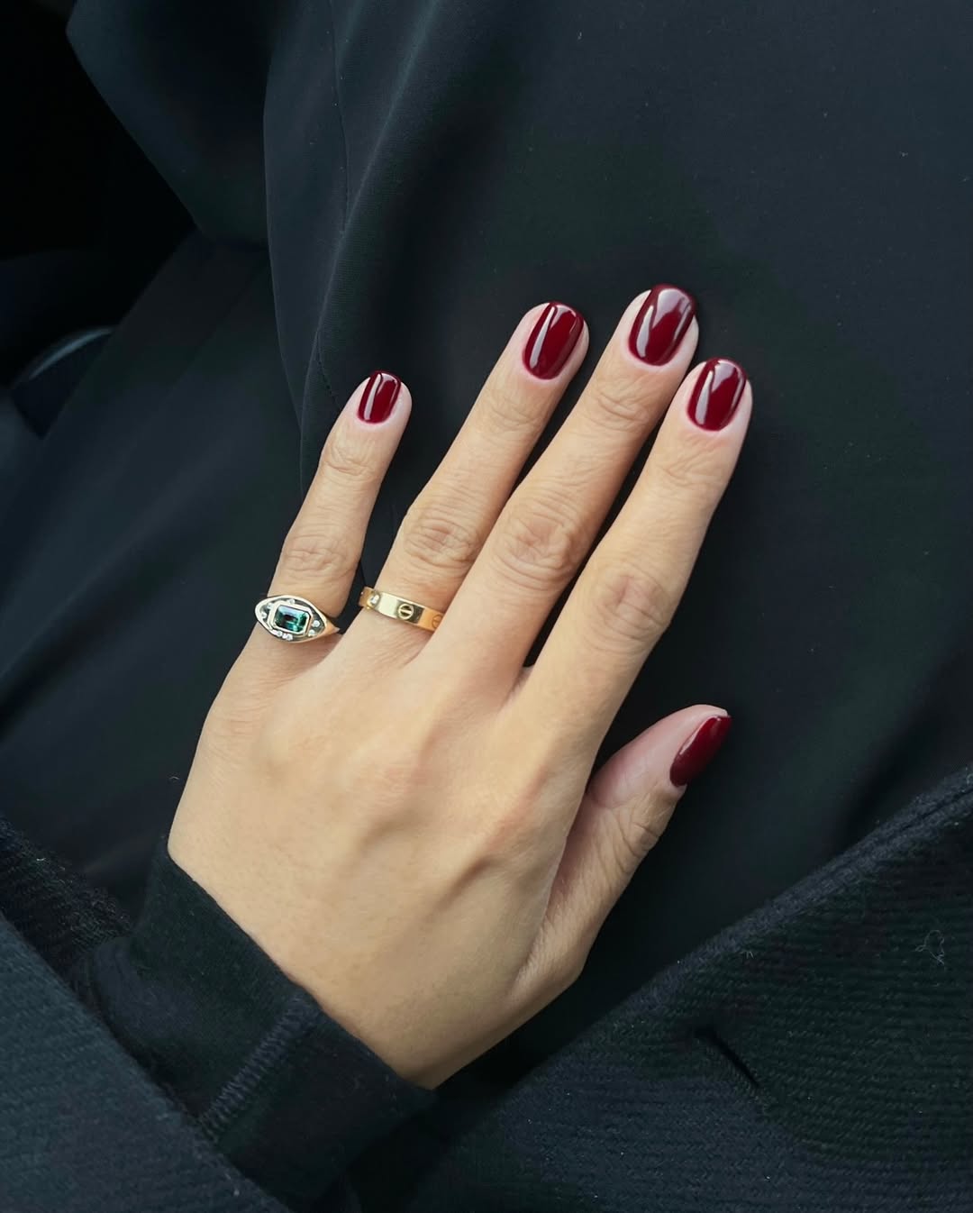 Foto de uma m&atilde;o com as unhas coloridas de vinho