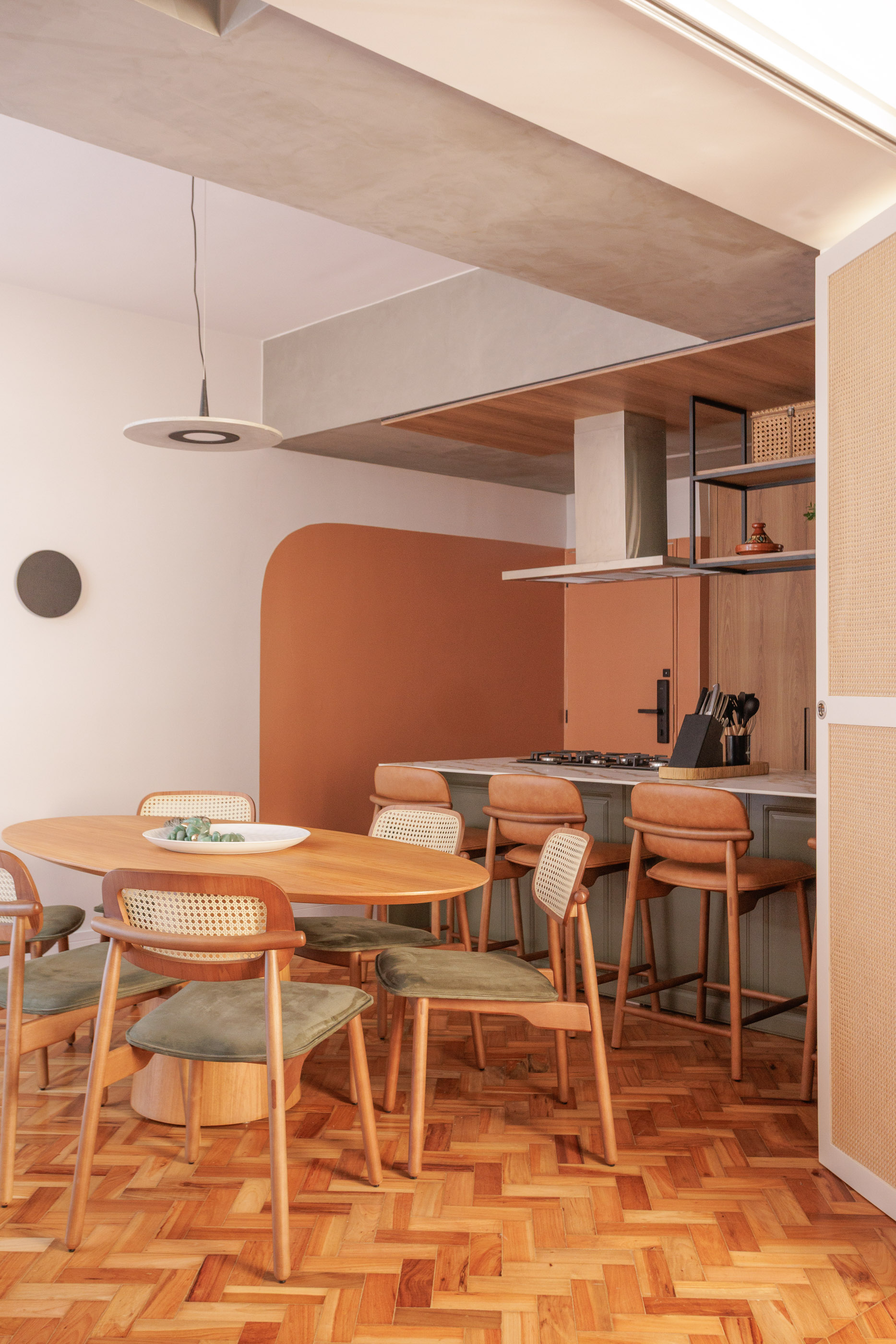 Apartamento com piso de taco, mesa de centro de madeira e cores terrosas