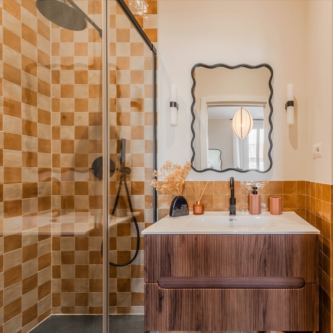 Banheiro com &aacute;rea de banho quadriculada laranja e branco e bancada de madeira