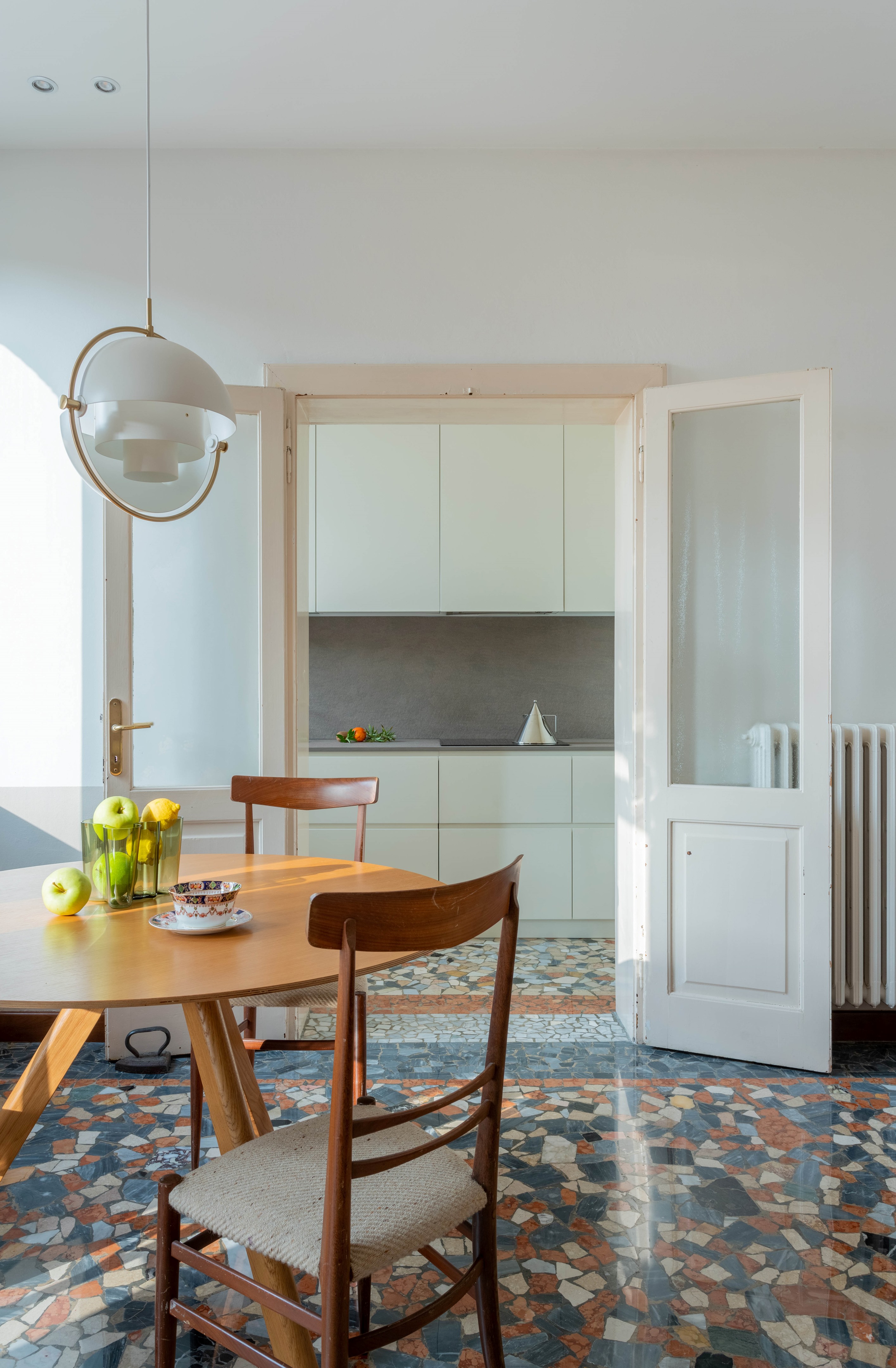 Sala de estar e cozinha integradas com piso de caquinho colorido