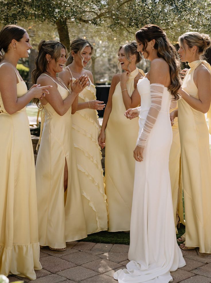 Imagem de noiva rodeada por madrinhas em vestidos de cor amarela
