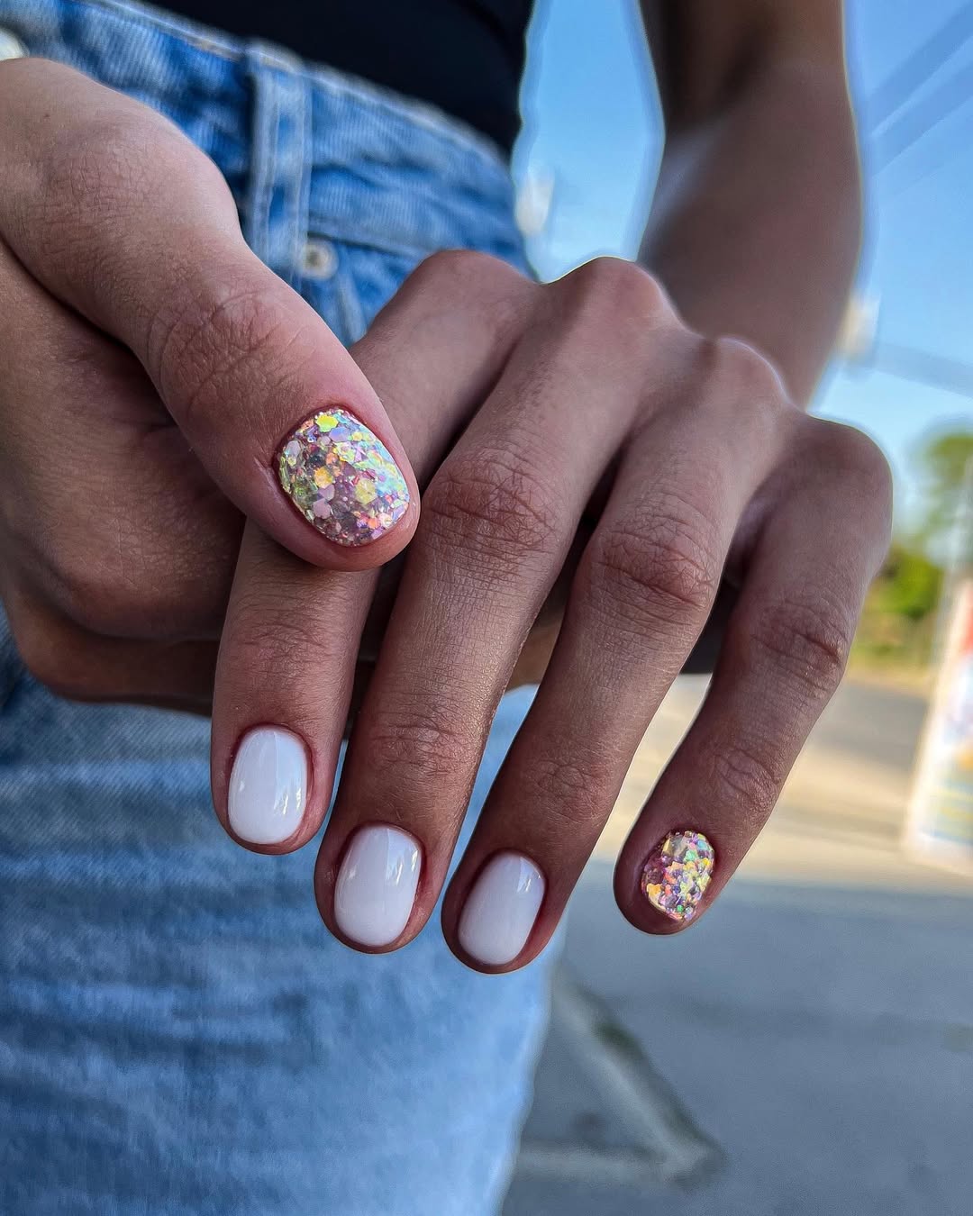 Unhas brancas decoradas com glitter hologr&aacute;fico em destaque