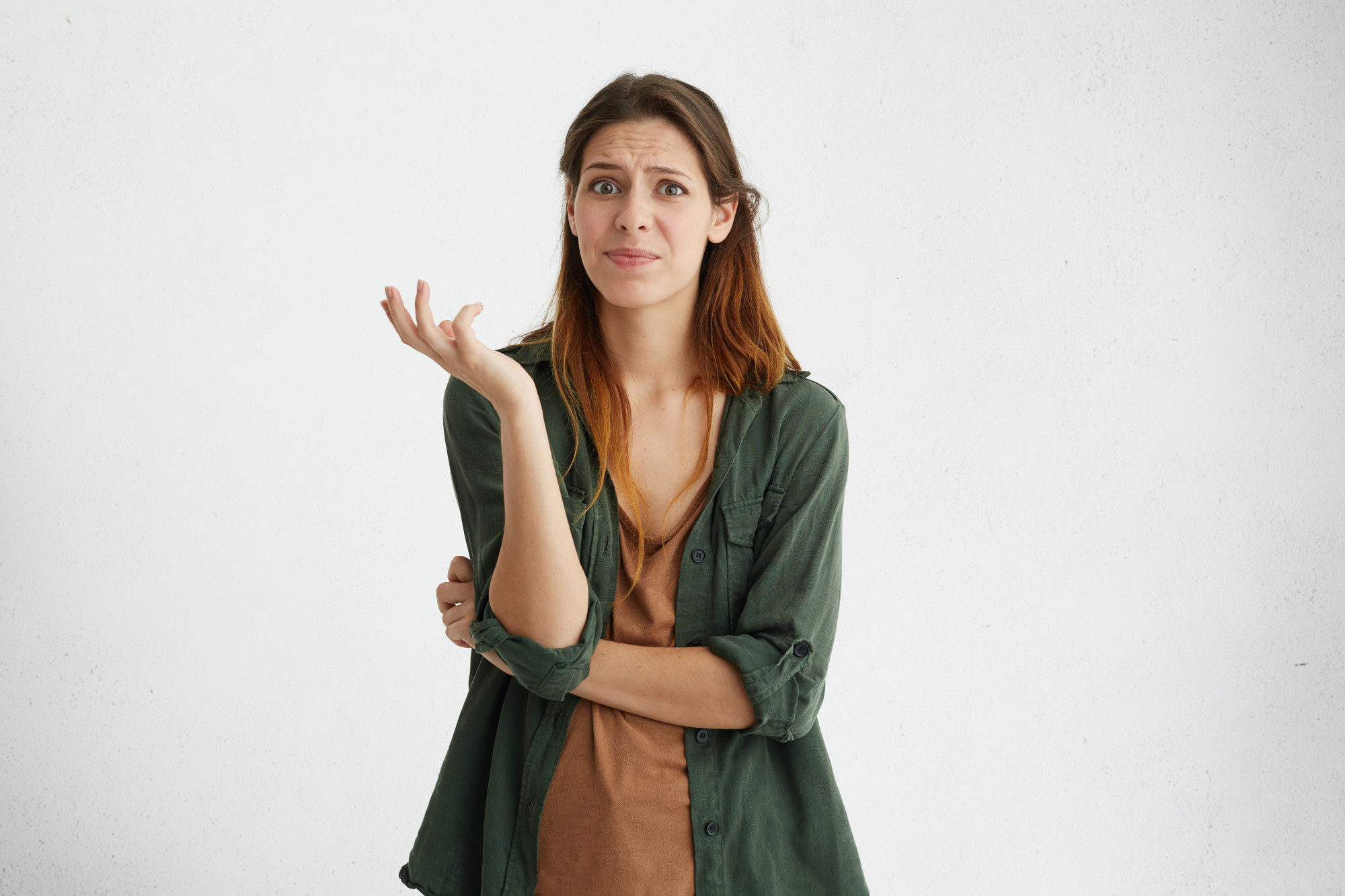 Mulher com express&atilde;o confusa e m&atilde;o levantada, representando reflex&atilde;o, autoconversa e organiza&ccedil;&atilde;o dos pensamentos.