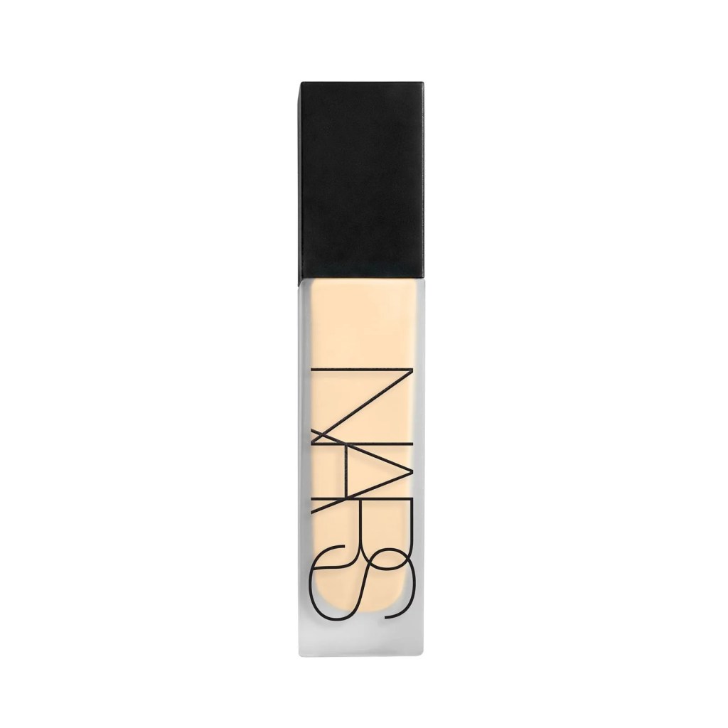 Frasco retangular de base NARS com tampa preta e corpo transparente contendo l&iacute;quido bege claro, sobre fundo branco