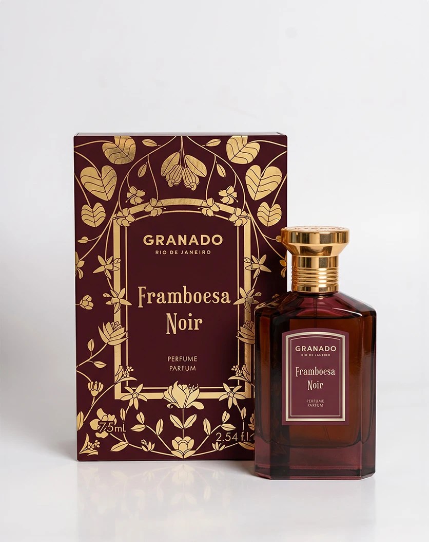 Frasco de perfume Granado Framboesa Noir em vidro marrom escuro com tampa dourada, ao lado de sua caixa bord&ocirc; com detalhes florais dourados, sobre fundo branco