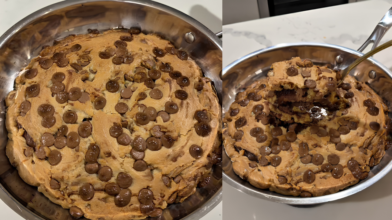 Massa de biscoito com gotas de chocolate em uma frigideira de metal, com uma colher dourada retirando uma porção do centro, revelando o interior macio e escuro